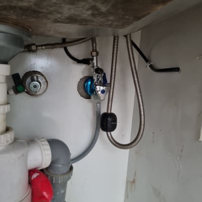 צנרת מתחת לכיור עם חיבורים וכלים