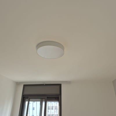 מנורה עגולה מותקנת על תקרה בחדר