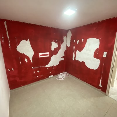קיר אדום עם תיקוני צבע לבנים בחדר ריק