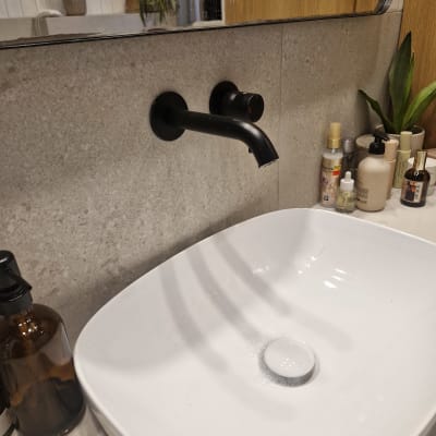 כיור וברז בחדר אמבטיה עם מוצרי טיפוח