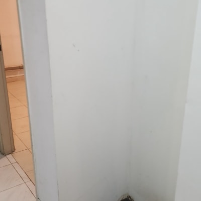 פינה ריקה עם קירות לבנים ורצפת אריחים