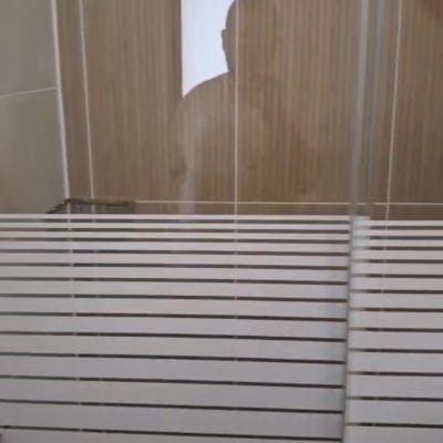 מקלחון עם דלת זכוכית וצללית אדם