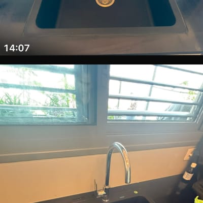 כיור שחור עם ברז על משטח שיש במטבח