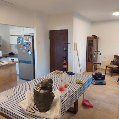 חדר עם כלים לצביעה, סולם ומברשת על הרצפה