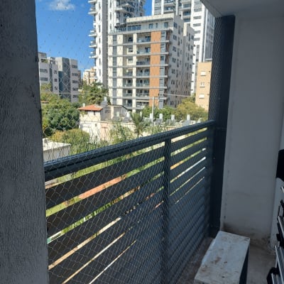 רשת מתכת מותקנת על מרפסת למניעת כניסת יונים