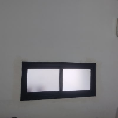 חלון אלומיניום עם זכוכית חלבית בקיר לבן