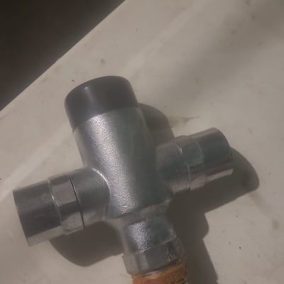 מחבר מתכת עם שלושה יציאות על משטח לבן