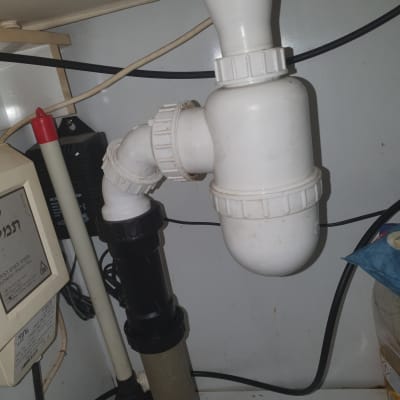 צנרת מתחת לכיור עם מחברים וכלים