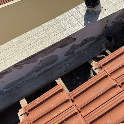 רעפים כתומים על גג עם קיר מתקלף