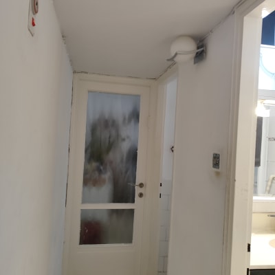 דלת זכוכית עם מסגרת לבנה במסדרון צר