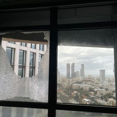 חלון זכוכית שבור עם נוף עירוני ברקע