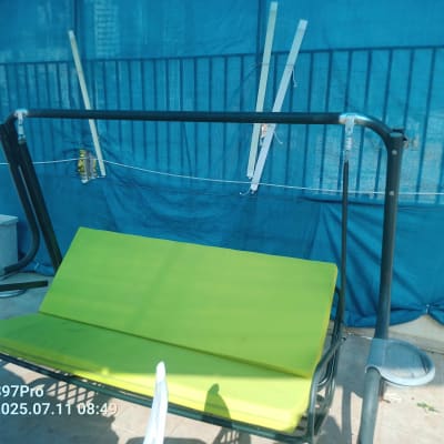 נדנדה ירוקה עם מסגרת מתכת על מרפסת