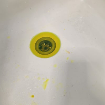 כיור עם כתמים צהובים סביב הניקוז