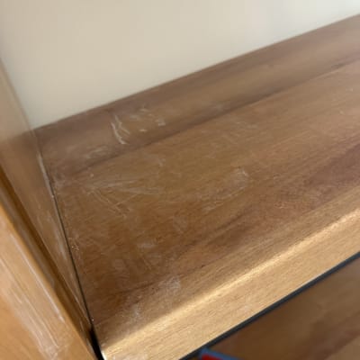 מדף עץ עם סימני אבק ומגב אדום