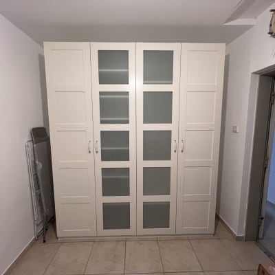 ארון בגדים לבן עם דלתות זכוכית בחדר