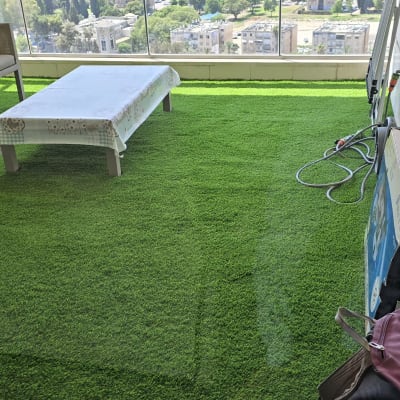 מרפסת עם דשא סינתטי, שולחן וכיסאות