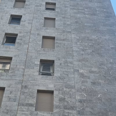 אדם על חבל מנקה חלונות בבניין גבוה