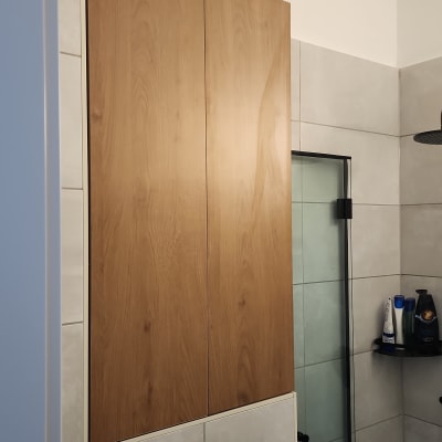 ארון עץ תלוי על קיר בחדר אמבטיה