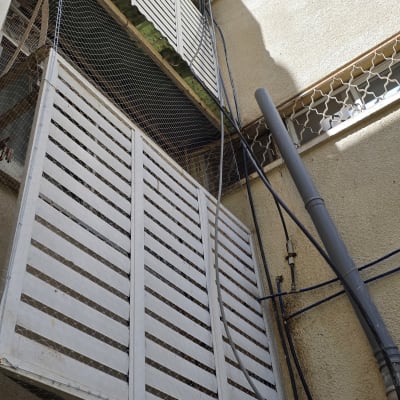 רשת מתכת מותקנת למניעת כניסת יונים למרפסת