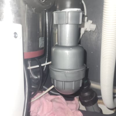 צנרת מתחת לכיור עם מגבת ורודה