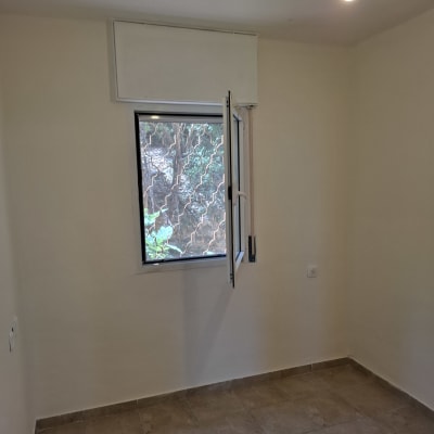 חדר ריק עם חלון פתוח ורצפת אריחים