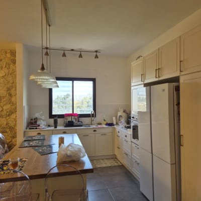 מטבח עם תאורה תלויה ותאורת מסילה