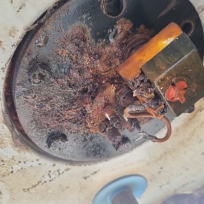 חלק תחתון של דוד שמש עם חלודה וחיבורים חשמליים