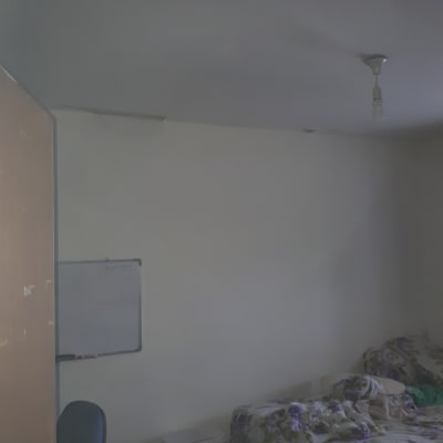 קיר צבוע בלבן עם לוח מחיק וכיסא