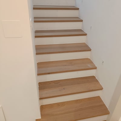 מדרגות עץ מותקנות בבית עם קיר לבן