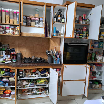 מטבח מאורגן עם ארונות פתוחים ומוצרי מזון מסודרים.