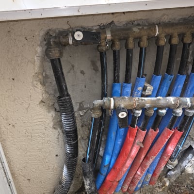 צינורות מים בצבעים שונים מותקנים בקיר