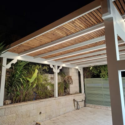 פרגולה מעץ עם תאורה מובנית בגינה