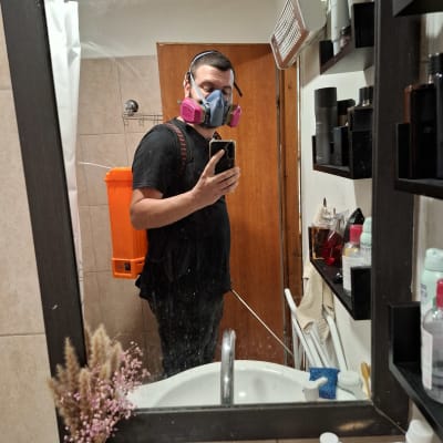 אדם עם מסכת מגן ותיק ריסוס כתום