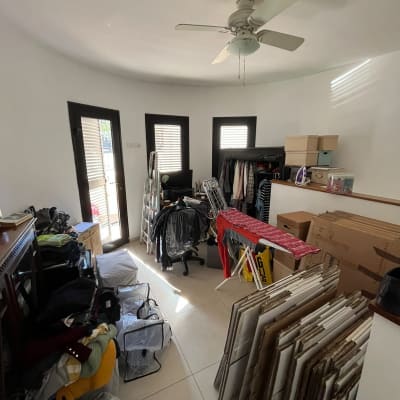 חדר עם קופסאות, בגדים ומאוורר תקרה