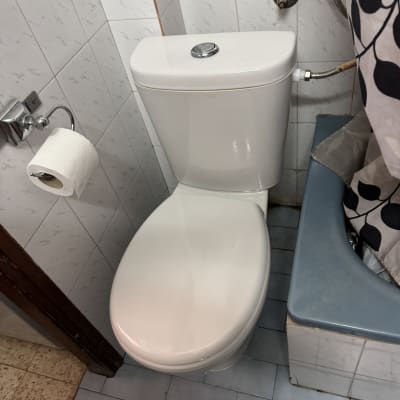 אסלה עם נייר טואלט וחיבורי מים