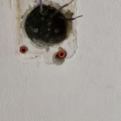 חוטי חשמל יוצאים מקופסת חיבורים בקיר