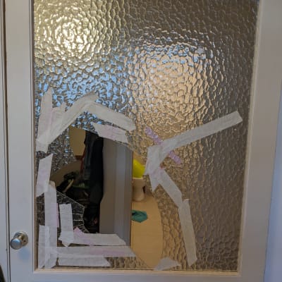 זכוכית שבורה עם סרטי הדבקה על דלת