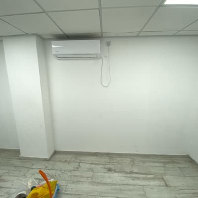 חדר עם קירות לבנים ומזגן מותקן