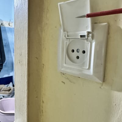 שקע חשמלי עם מכסה פתוח וכלי עבודה אדום