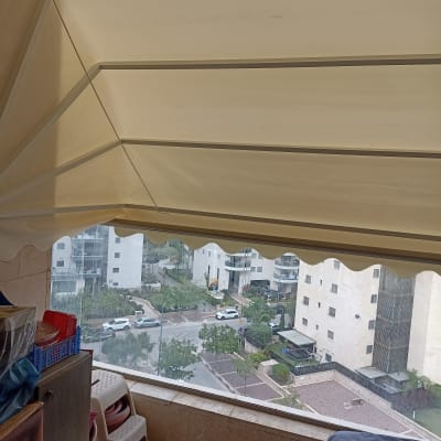 סוכך בד לבן עם תמיכה מתכתית במרפסת