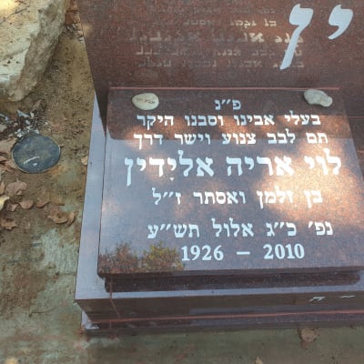 מצבה עם כיתוב בעברית ושני אבנים קטנות
