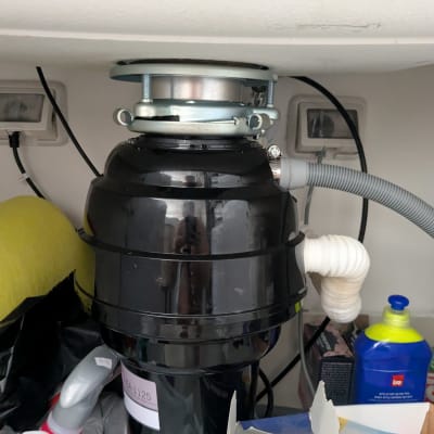 מתקן טוחן אשפה מתחת לכיור עם צינור מחובר