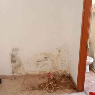 קיר עם סימני רטיבות ונזק, ללא אנשים או טקסט.