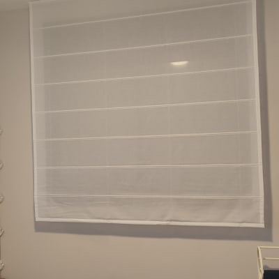 וילון לבן תלוי על קיר בחדר שינה