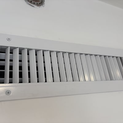 פתח אוורור נקי ומסודר על קיר לבן