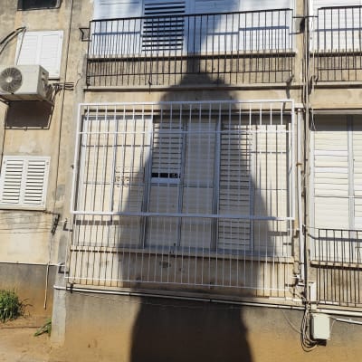 צל של אדם על קיר עם סורגים וחלונות