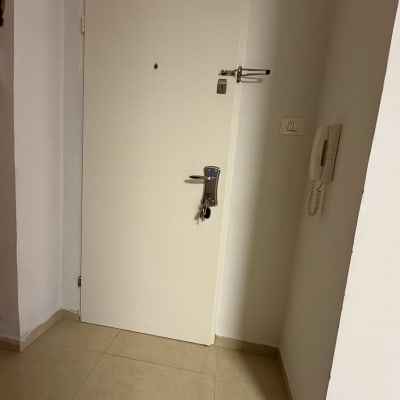 דלת לבנה עם מנעול ובריח מתכת