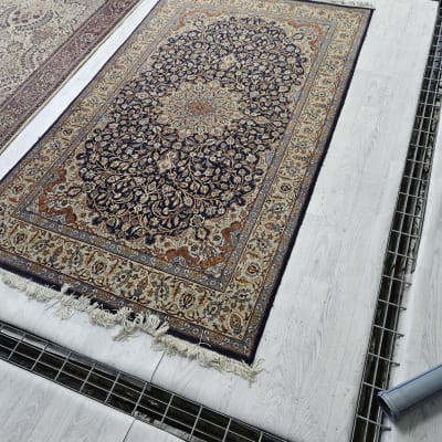 שטיחים מונחים על רשת מתכת לניקוי