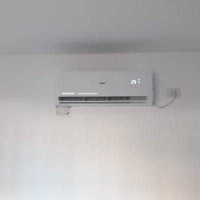 מזגן מותקן על קיר עם תצוגת טמפרטורה 29 מעלות