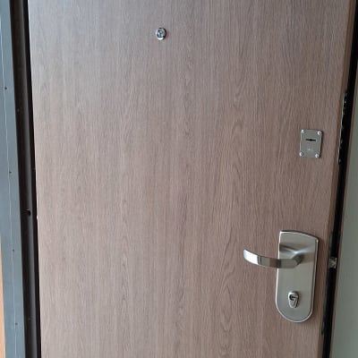 דלת עץ עם ידית מתכת ומנעול